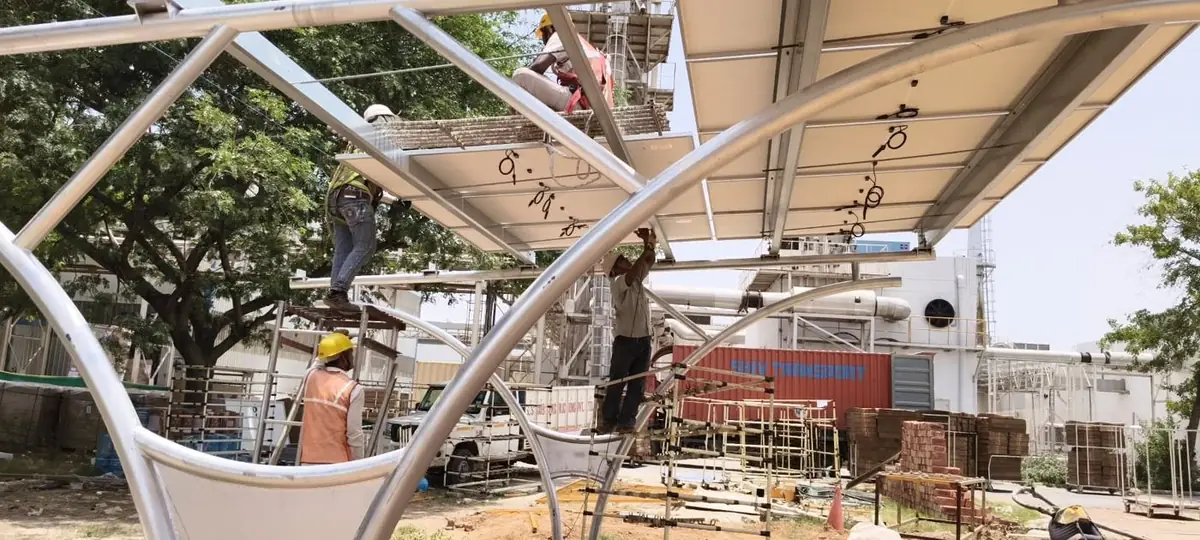 Crew in safety harnesses installing solar modules on the carport structure