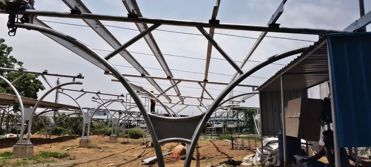 Curved steel arches and purlins of the carport frame before modules are fitted